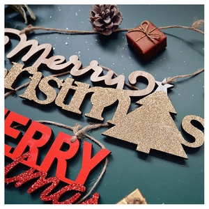 Detailed close-up of wooden Merry Christmas hanging ornament with gold glitter finish
