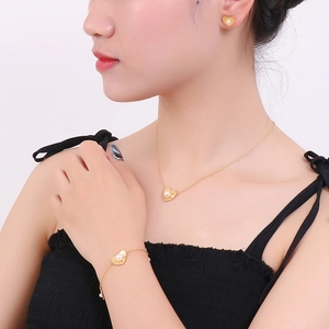 Golden heart-shaped jewelry set with white pearls including necklace, bracelet and earrings