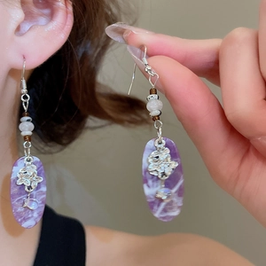 Detail view of vintage resin drop earrings with purple sand texture and silver cutout
