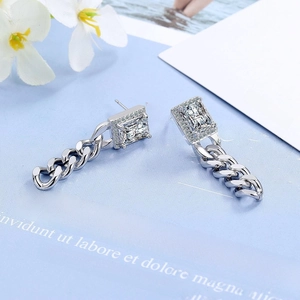 Macro detail of silver rectangular zircon earrings with chain links and pavé crystals