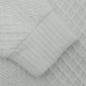 Détail du tissu blanc texturé avec poignet côtelé et motif de tricotage en relief