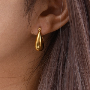 Chic hollow U-shaped golden teardrop earrings on model with high-shine metallic finish