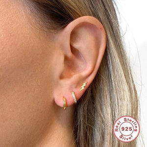 Detail of 925 sterling silver earring set with gold lightning stud and pavé zircon ring