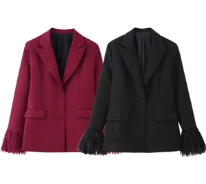 Dettaglio delle piume sui polsini di completi blazer attillati in bordeaux e nero