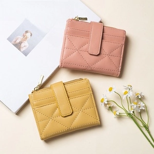 Close-up of diamond-quilted PU leather cardholders in yellow and pink with metal zipper