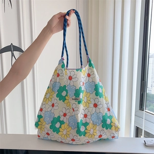 Close-up of floral canvas tote bag with blue rope handle in a bright interior setting