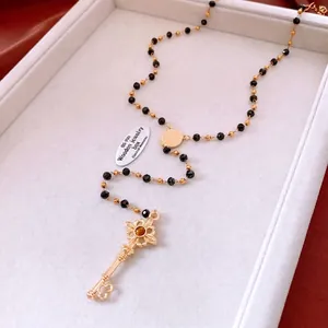 Collier de perles vintage avec un pendentif clé détaillé et une pierre ambrée chic
