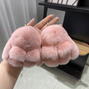 Close-up of a pair of pink plush animal paw keychains made of soft rex rabbit fur