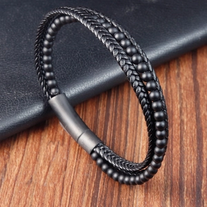 Detail of men's layered black braided leather bracelet with matte magnetic clasp