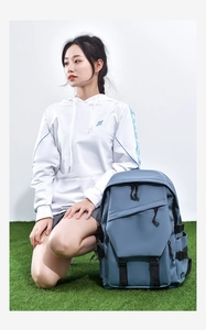 Blue versatile large-capacity backpack shown next to a model on green grass