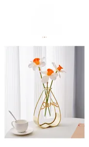 Detail of a heart-shaped gold iron vase with a glass tube and Narcissus flowers