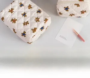 Quilted cream cosmetic bag with brown bear pattern and durable top handle