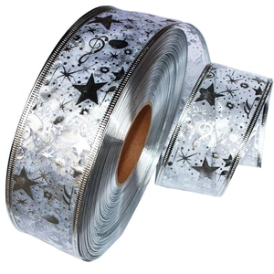 Macro detail of silver holiday ribbon roll with black star and musical note prints