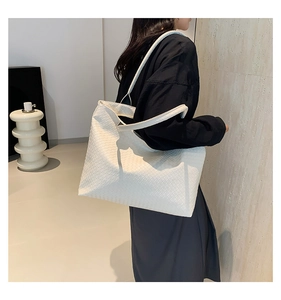Detail of white woven leather tote bag showing large capacity and intricate knit texture