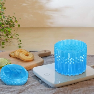 Close-up of a blue faceted resin storage jar with lid on a heating base for DIY crafts