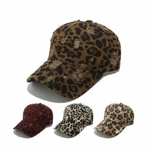 Close-up of distressed leopard baseball caps with ripped holes and worn details in multi-colors