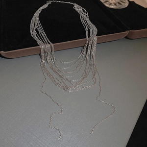 Dettaglio di collana multifilo argentata a frange drappeggiata su una scatola nera