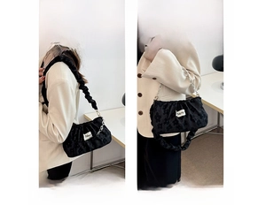 Detail of black pleated cloud bag with silver chain and dual styling as shoulder and handbag