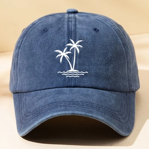 Close-up of white palm tree and wave embroidery on blue washed cotton baseball cap