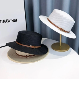 Detail of woven straw hats with leather straps and gold buckles in three colors