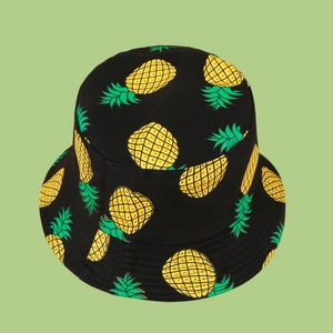 Detail of yellow pineapple prints on black cotton canvas bucket hat fabric