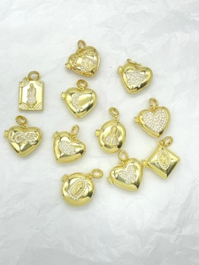 Macro shot of assorted gold plated heart and book lockets with inlaid cubic zirconia