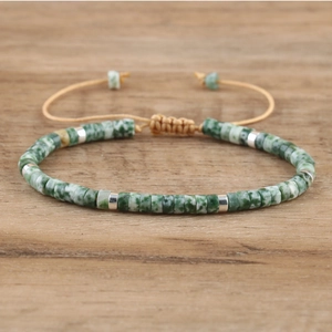Macro detail of natural imperial stone beads and silver spacers on adjustable woven bracelet