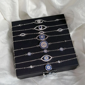 Detailaufnahme mehrerer S925 Sterlingsilber Armbänder mit blauem Zirkonia Auge