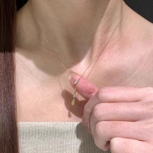 Minimalist Y-shaped brushed gold necklace with drop pendant and zircon on collarbone