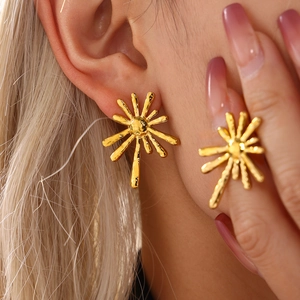 18K gold plated sunburst stud earrings with irregular radiating design on a female model