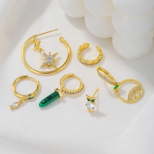 Golden S925 star tassel and geometric earrings set with green stones on white silk
