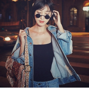 Close-up of retro steampunk round sunglasses worn in an urban night street setting
