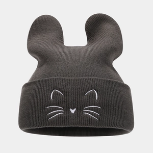 Detail of dark grey knit hat showing animal ears and white cat face embroidery
