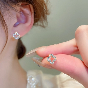 Sparkling silver four-leaf flower stud earrings with hollow design and inlaid stones