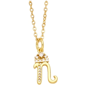 Macro shot of polished gold letter n pendant with sparkling cubic zirconia on fine chain