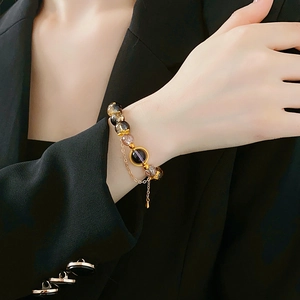 Close-up of vintage beaded bracelet with dark translucent glass and gold hollow charms