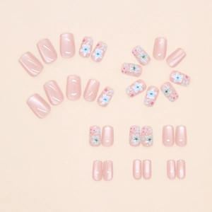 Detail of camellia press-on nails with cat eye shimmer and floral nail art patterns