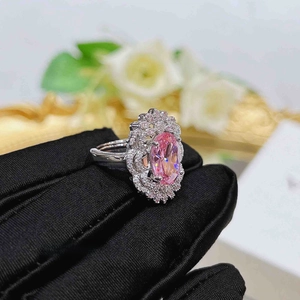 Macro side view of a luxury pink oval gem ring set in floral white gold with diamonds