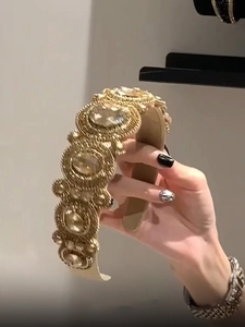 Macro detail of luxury gold beadwork and shimmering gemstones on a vintage headband