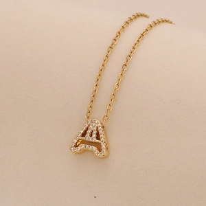 Detailed view of golden letter A pendant with sparkling zircons on O-chain necklace