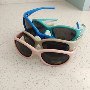 Detail view of four colorful kids' sunglasses with UV400 protection and matte finish