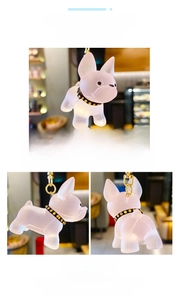 Macro detail of French Bulldog keychain made of translucent pink resin with gold collar