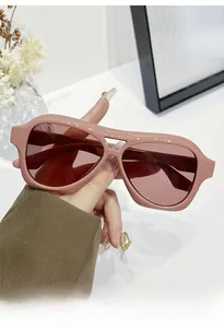 Close-up of stylish aviator sunglasses with pink frames and dark burgundy gradient lenses