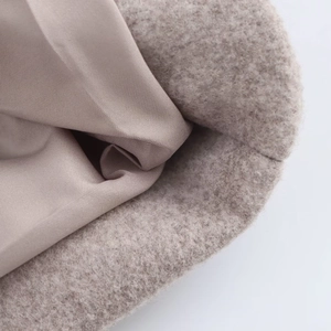 Elegant beige wool coat with warm lining and plush fabric texture in a close-up view