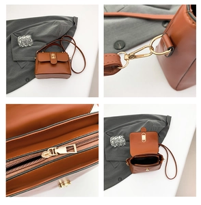 Detail view of brown faux leather handbag showing gold hardware, strap hooks and interior space