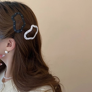 Polka dot wave hair clips worn on brown hair showing a stylish and cute hair accessory