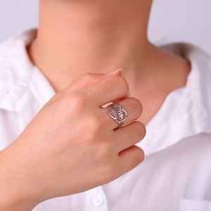 Detailed view of silver MOMMY heart ring with flower detail on model's hand