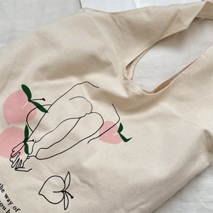 Detail of canvas tote bag showing peach art print and high-quality fabric texture
