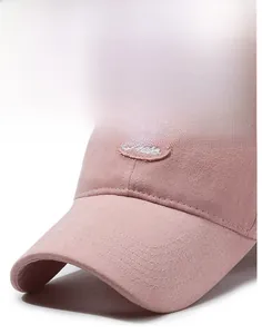 Detail of rose pink cotton baseball cap featuring reinforced brim and oval logo embroidery