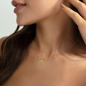 Gros plan détaillé du pendentif papillon évidé en acier inoxydable plaqué or 18 carats